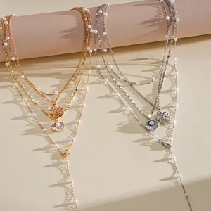Detail view of multi-layered necklaces with pearl, shell, and flower charms in gold and silver