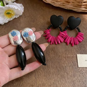 Close-up of stylish acrylic teardrop flower earrings with delicate rose accents