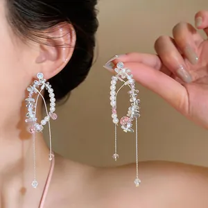 Detail view of elegant oval drop earrings with pearls and long silver tassels for women