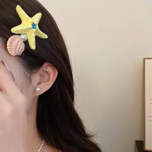 Close-up detail of a colorful starfish and shell hair clip worn on long brown hair for summer