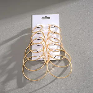 Detail shot showing a set of six pairs of graduated gold hoop earrings on a white card.