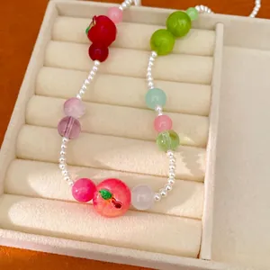 Colorful resin apple beaded necklace for women presented in a cream jewelry display tray
