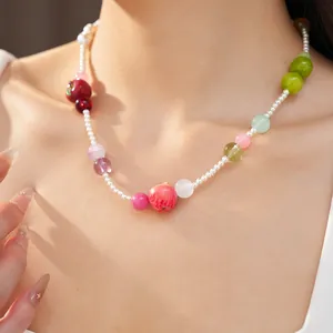 Detail view of a colorful resin apple bead necklace worn on a model's neck for summer