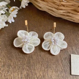 Eleganti orecchini a fiore in garza di neve bianca con perle e perni placcati oro.