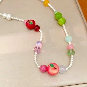 Close-up of colorful resin apple and pearl beads on a sweet summer style women necklace