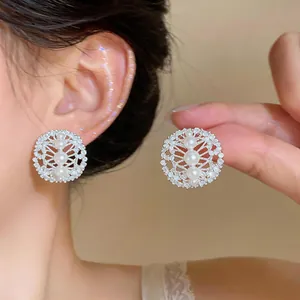 Detailed shot of silver needle zircon hollow pearl earrings with elegant luxury design.