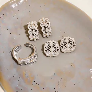 Close-up of elegant silver hollowed-out jewelry set with white pearls and zircons