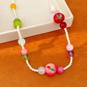 Macro view of colorful resin fruit charms and small pearls on a sweet summer style necklace