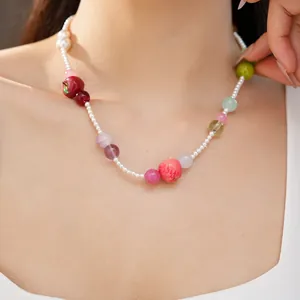 Close-up of a colorful resin apple necklace on a female model's clavicle area