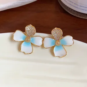 Close-up detail of gradient enamel flower earrings with gold finish and zircon stones