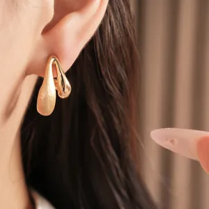 Close-up of 18k gold plated teardrop earrings showing matte and polished textures