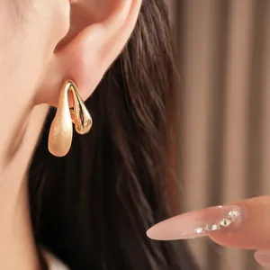 Close-up of 18k gold plated waterdrop earrings with brushed and polished finish
