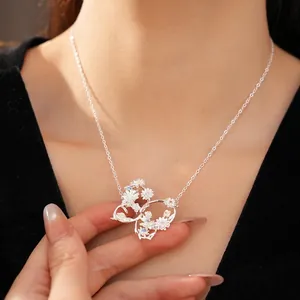 Elegant silver butterfly pendant necklace with zircon flower details worn by a model