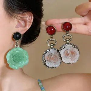 Detailed view of elegant resin rose flower drop earrings with antique metal finish