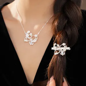 Detail view of zircon butterfly hair clip and matching necklace on model