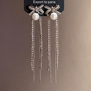 Elegant silver needle bow earrings with shimmering rhinestones, pearls, and long tassels