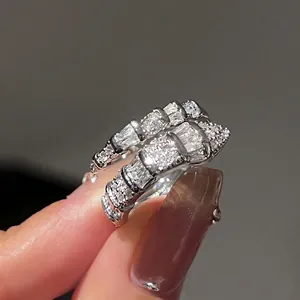 Close-up of sparkling silver snake ring with square zircon stones for luxury style.