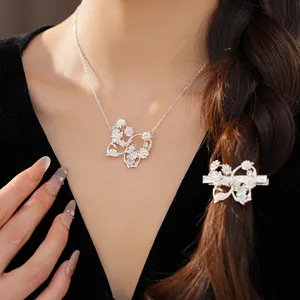 Detail shot of silver butterfly necklace and hair clip with zircon flowers.
