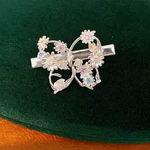Close-up of silver butterfly hair clip adorned with colorful flower-shaped zircons.