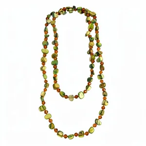 Long Bohemian green shell beaded necklace with amber crystal accents on white background