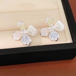 Primo piano dettagliato di orecchini a lobo a fiore con perle e zirconi scintillanti