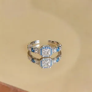 Elegante dettaglio di un anello aperto in argento con zircone blu e trasparente