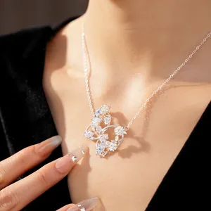 Macro detail of intricate silver butterfly necklace pendant with colorful zircon flowers