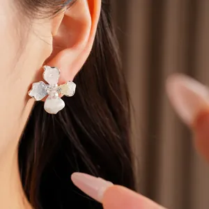 Eleganti orecchini a fiore con perle e dettagli in zirconia indossati sul modello