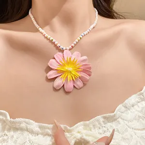Detailed close-up showing a sweet pearl beaded necklace featuring a large pink flower pendant