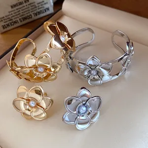 Detailansicht eines eleganten Metallblumen-Schmucksets mit zentralen Perlenakzenten