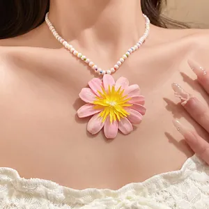 Close-up of sweet pink flower pendant necklace with white pearl and colored beads