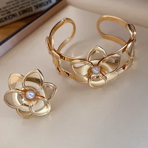 Exquisites vergoldetes Blumen Armband und Ring Set mit Perlen auf elegantem Stoff