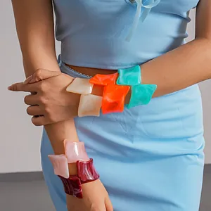 Detailed view of colorful marbled resin geometric cuff bracelets with irregular twisted design