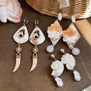 Seaside vacation style earrings with resin roses, shell conchs, and baroque pearls.