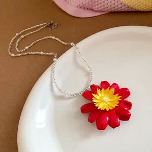 Gros plan d'un collier de perles marguerite sur une assiette en céramique