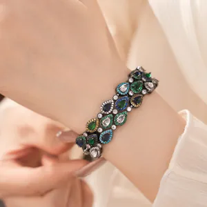 Detailansicht eines Vintage-Armbands mit bunten Zirkonia in Birnenform am Handgelenk.