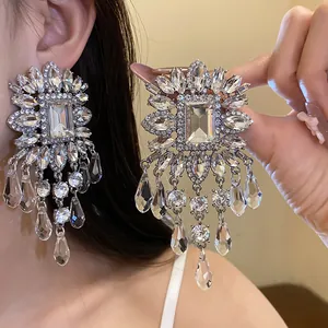 Detail shot of sparkling oversized crystal fringe earrings for elegant evening parties.