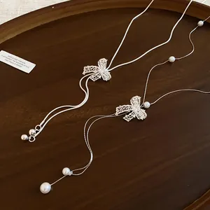 Detailed view of elegant French style long Y-shaped necklace with crystal bow and pearls