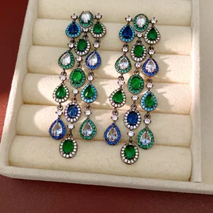 Detaillierte Makroansicht von Vintage-Zirkon-Quastenohrringen mit grünen Steinen