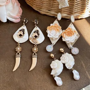 Collection of vintage shell, rose, and horse-themed dangle earrings for seaside style.