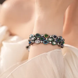 Nahaufnahme eines Vintage-Armbands mit mehrfarbigen Tropfen-Zirkonia am Handgelenk