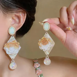 Close-up showing the intricate vintage rose design, marble texture base, and iridescent bead drop