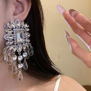 Close-up of oversized silver statement earrings with shimmering clear crystal fringes