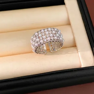 Elegant multi-layer pearl open ring with sparkling cubic zirconia accents.