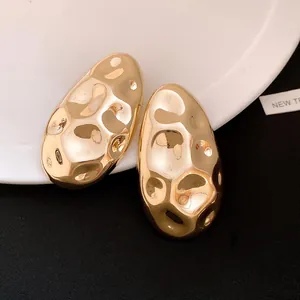Close-up detail of vintage gold oval stud earrings with unique hammered texture.