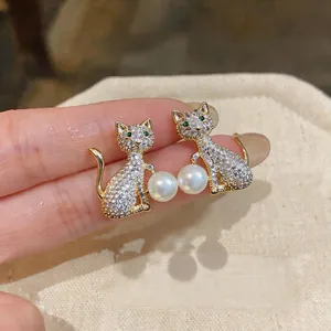 Gros plan de boucles d'oreilles chat élégantes avec zircons brillants et perles