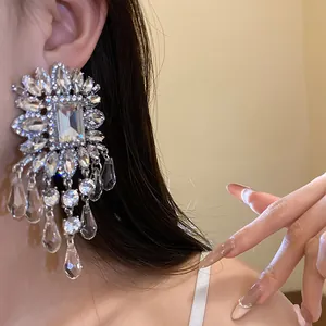 Detailed view of heavy rhinestone flower tassel earring worn for elegant banquet style