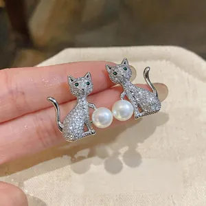 Détail de boucles d'oreilles chat en argent avec oxydes de zirconium et perles.