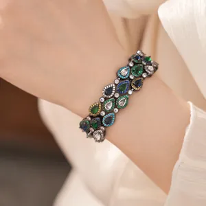 Detailansicht eines Vintage-Armbands mit mehrfarbigen Zirkonsteinen im Tropfenschliff