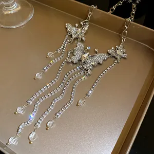Detailed view of luxury rhinestone butterfly tassel necklace on elegant golden tray
